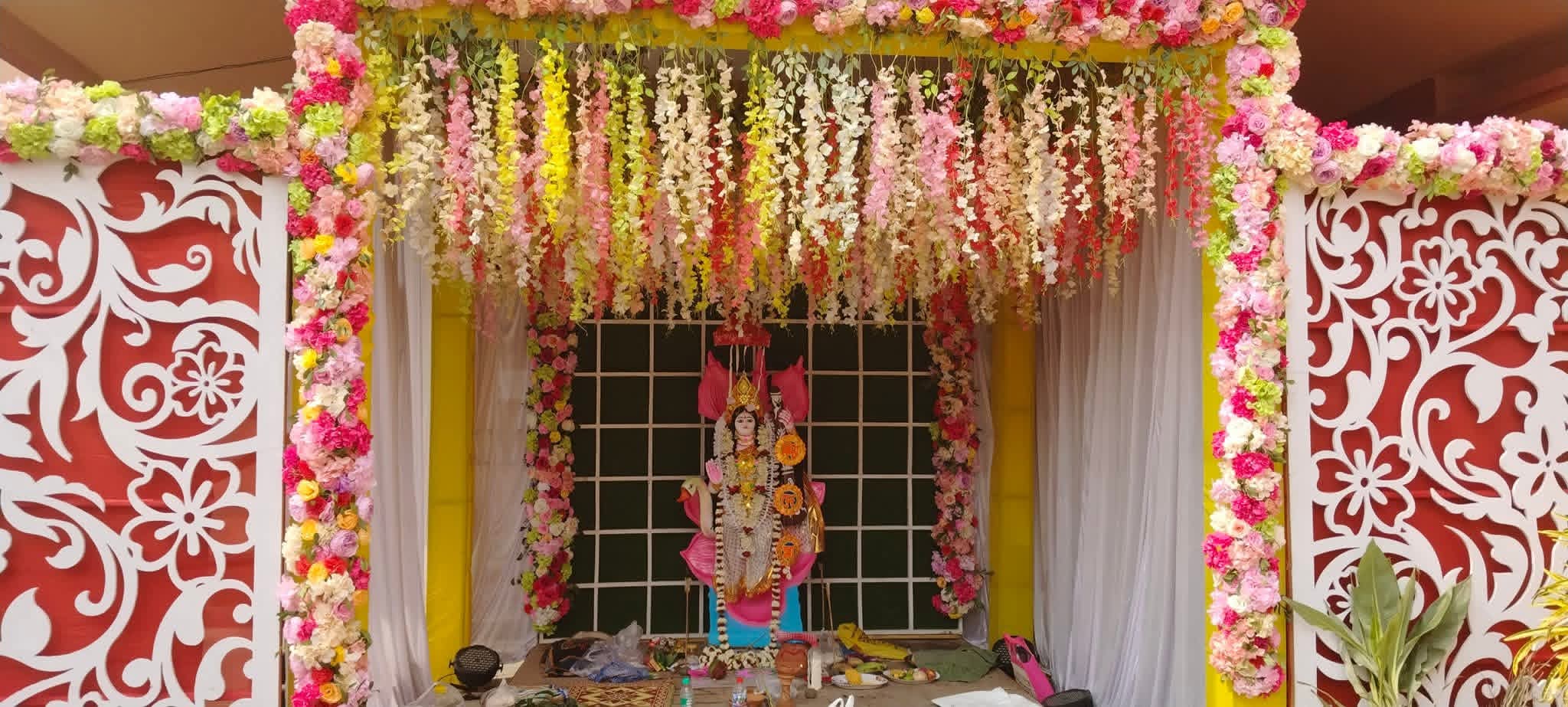 Saraswati Puja pandal decorated with hanging floral garlands