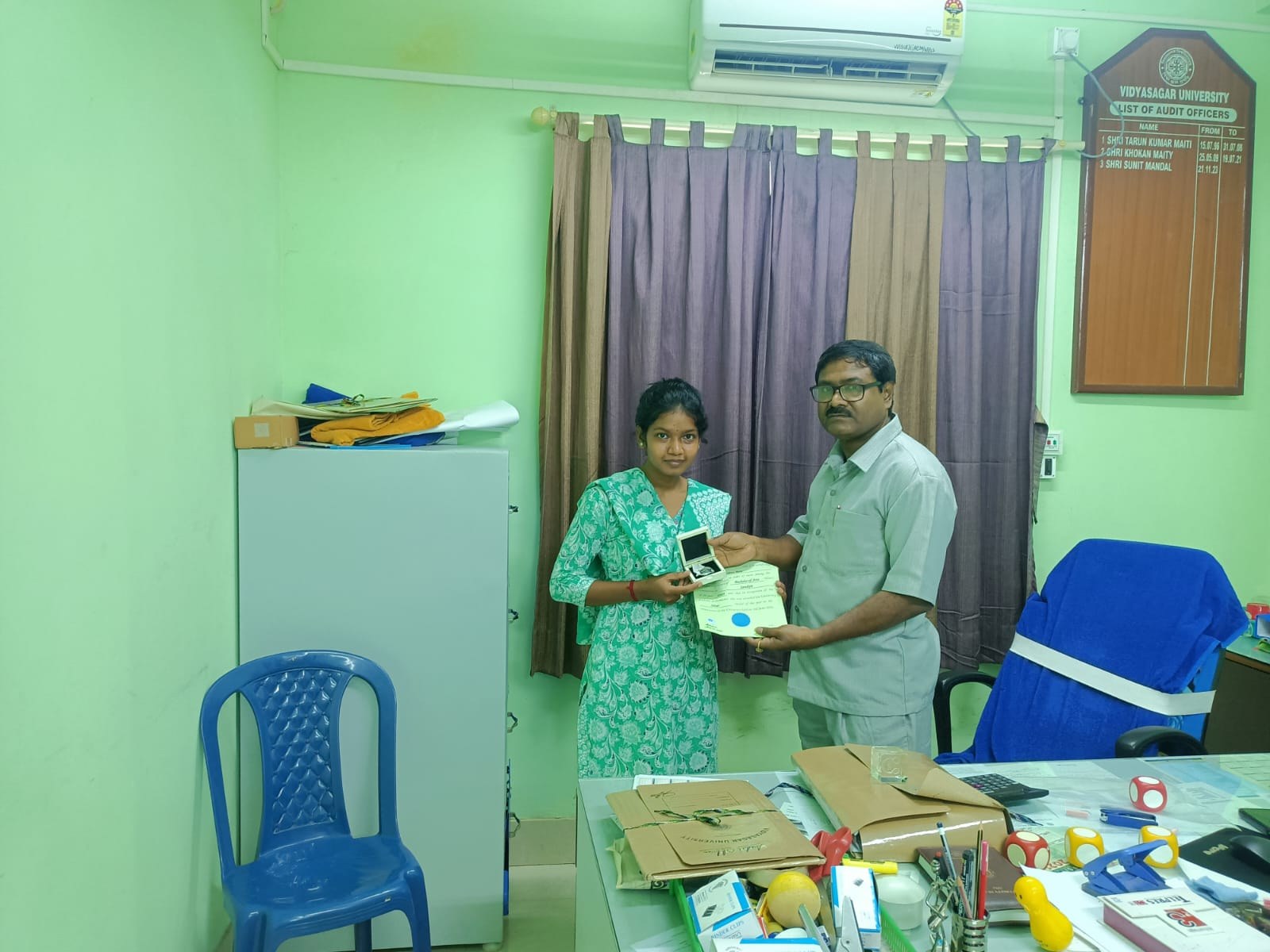 Nilima Bera receiving the Silver Medal from a College official