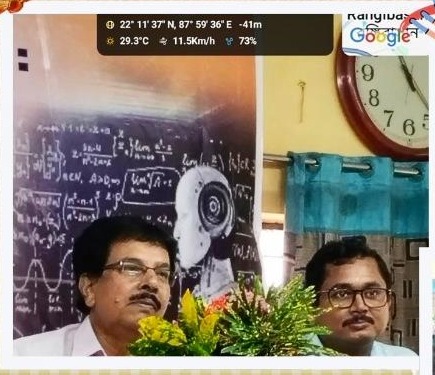 Two speakers seated at a table with flowers during the lecture series on Bharatkeshari Shyama Prasad Mukhopadhyay