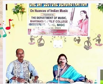 A man and woman performing with musical instruments beneath a banner for the Nuances of Indian Music lecture demonstration